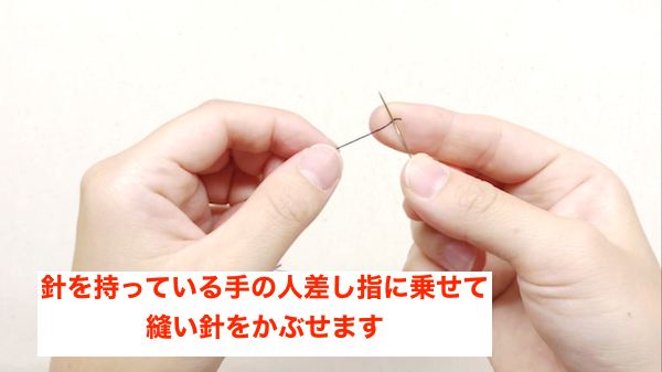 長い糸の上に縫い針を乗せる